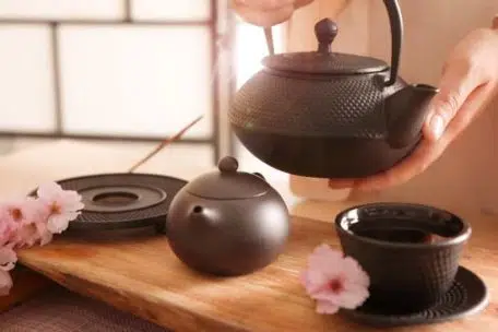 master conducting traditional tea ceremony at table indoors, clo