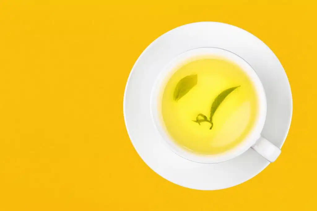 cup of green oolong tea over yellow 2022
