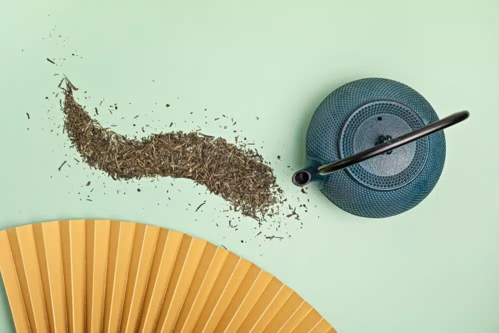 tea leaves and blue teapot on green surface 2026 09 24 03 34 34 utc Tie Guan Yin jasna czy prażona? Jak wybrać i porównać dwa style oolonga